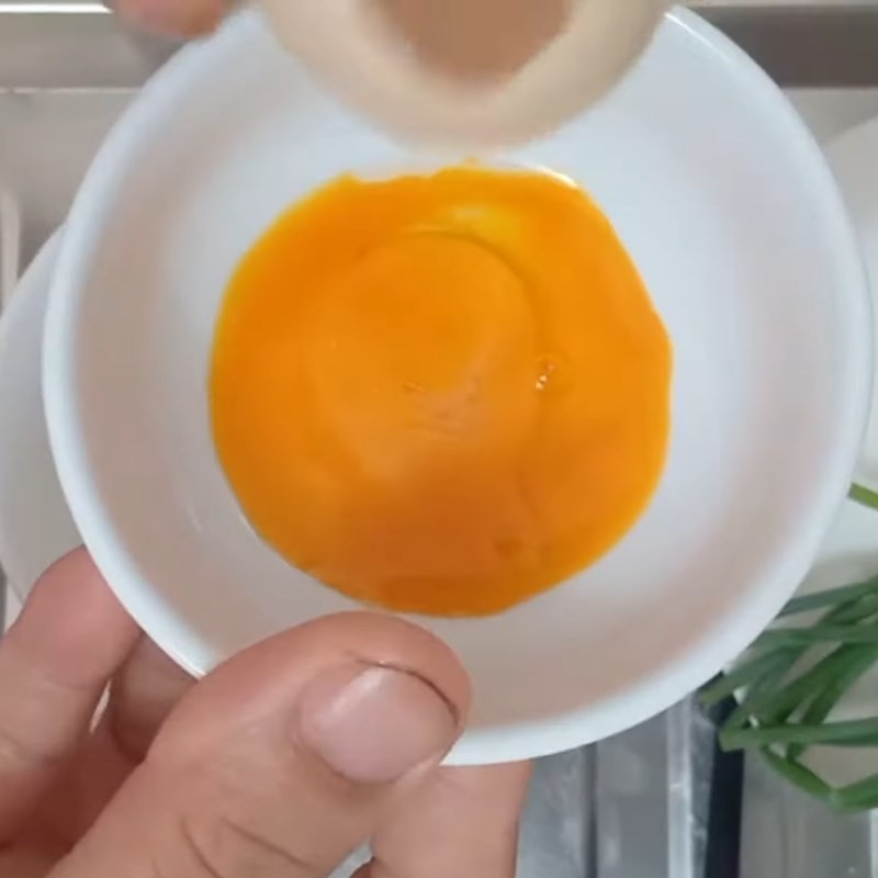 Lòng đỏ trứng gà được đánh tan chuẩn bị cho món cháo trứng cà chua
