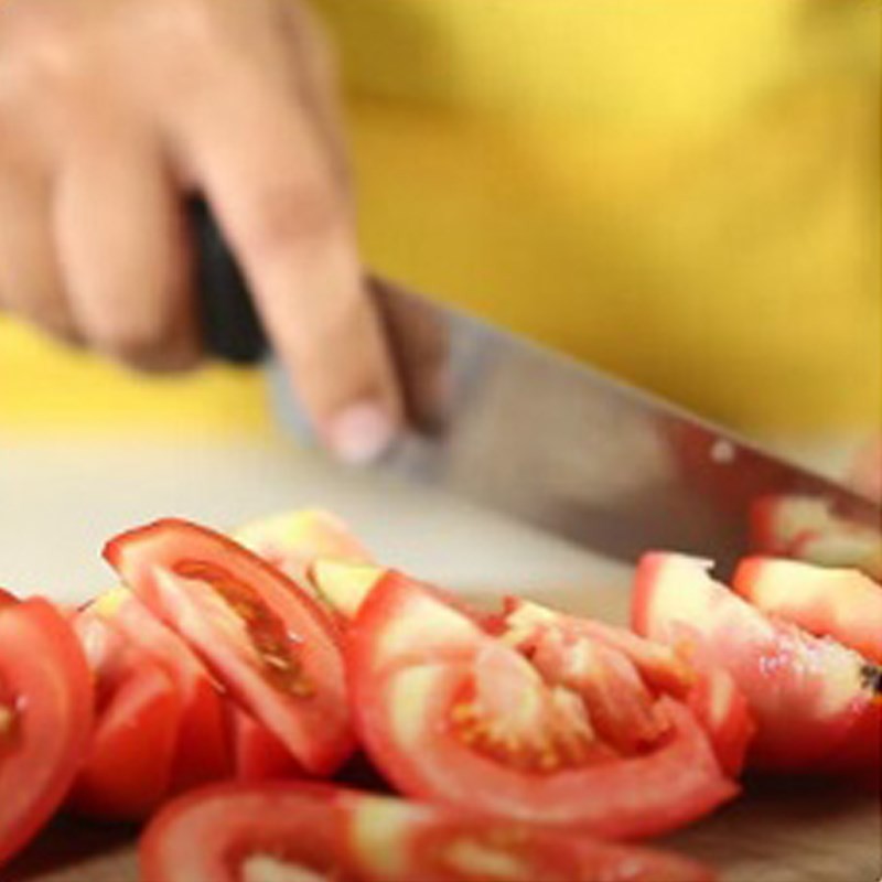 Dứa và cà chua được cắt miếng, chuẩn bị cho món canh ngao nấu dứa