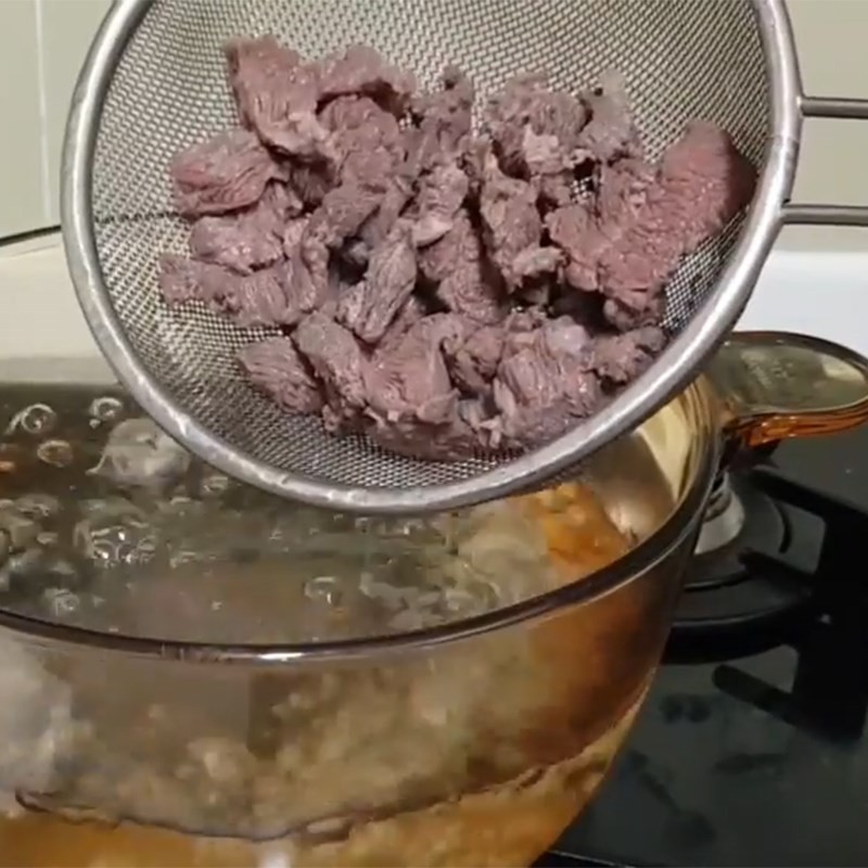Vớt thịt bò đã trụng sơ ra khỏi nồi, rửa sạch lại trước khi nấu canh thịt bò kiểu Hàn Quốc