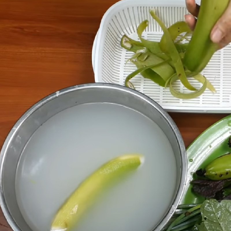 Ngâm chuối xanh đã gọt vỏ trong nước muối loãng để loại bỏ nhựa và giảm độ chát khi nấu cá