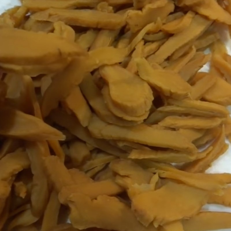 Cắt lát mỏng củ cải muối (xá bấu) để chuẩn bị cho cách nấu canh củ cải muối, giúp dễ dàng khử mặn và thấm gia vị