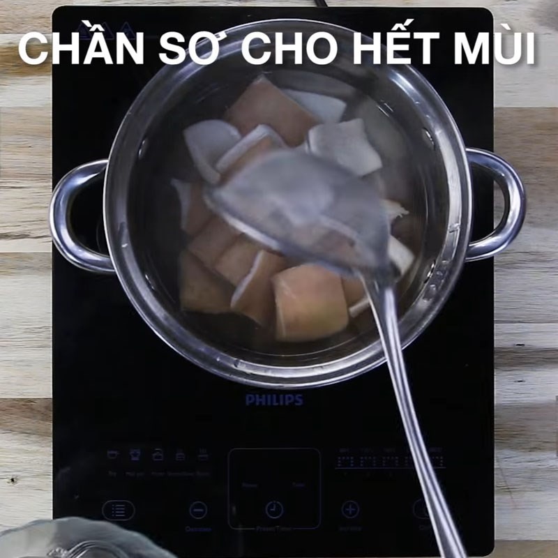 Chần sơ da heo trong nước sôi để làm sạch và giòn hơn
