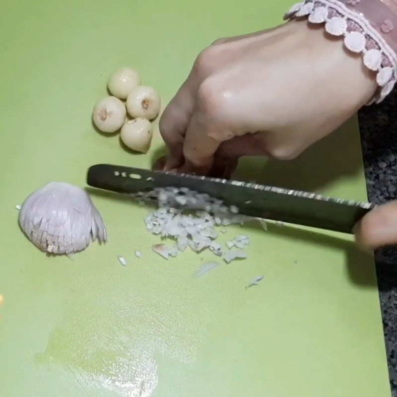 Hành tím và tỏi được băm nhuyễn, chuẩn bị làm gia vị ướp thịt cho món thịt khìa ăn kèm xôi mặn lá dứa