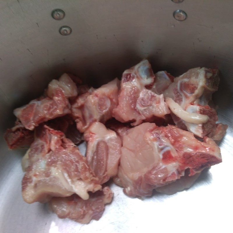 Sơ chế xương heo bằng cách trụng qua nước sôi giúp canh khoai sọ hầm xương trong hơn