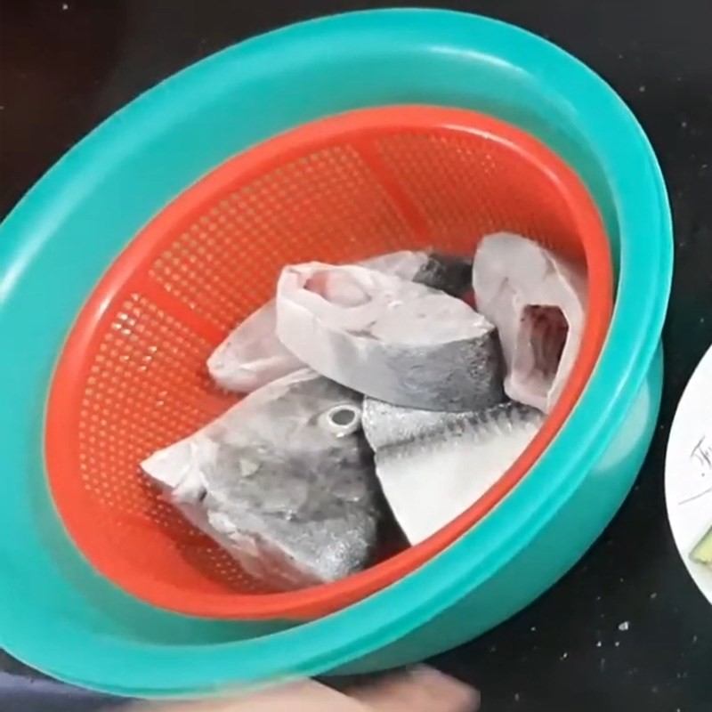 Cá chim tươi được cắt khúc và ướp nhẹ với muối, chuẩn bị cho cách nấu lẩu cá chim chua cay