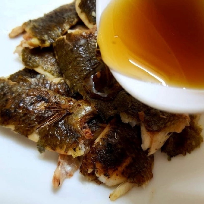 Gỡ thịt cá rô sau khi nướng để nấu canh rau cải