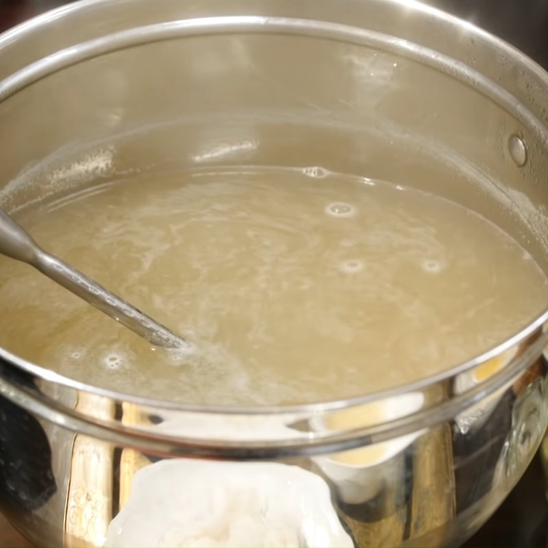 Nước dùng bún ốc nguội đã hoàn thành, trong veo và đậm đà hương vị
