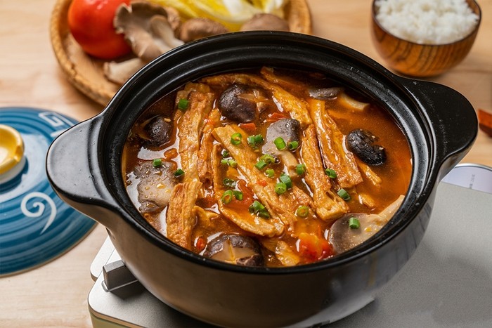 Món canh váng đậu nấu nấm cà chua thành phẩm, nóng hổi và hấp dẫn, sẵn sàng thưởng thức.