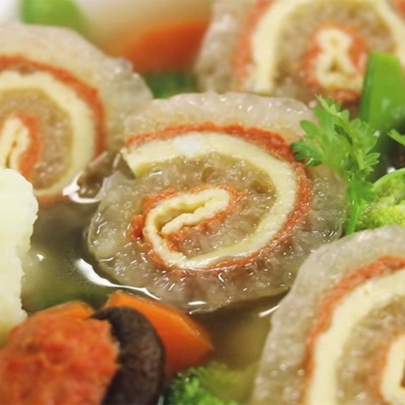 Cận cảnh bát canh bóng bì lợn với các cuộn bóng đẹp mắt, rau củ và nước dùng trong veo
