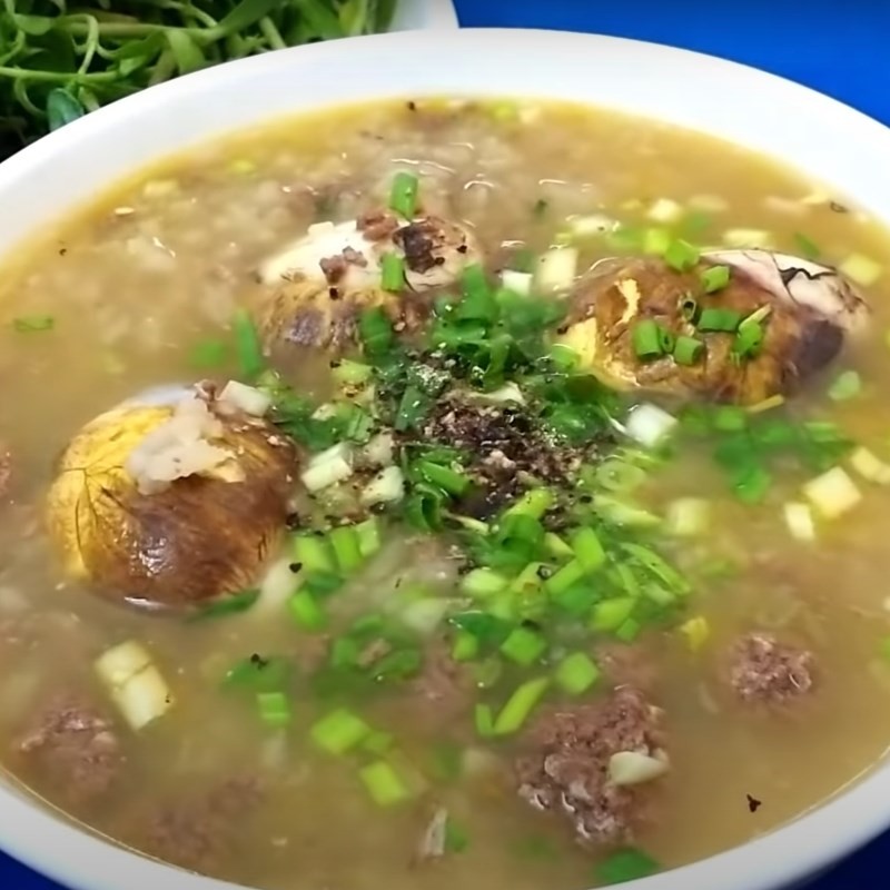 Bát cháo cua đồng hột vịt lộn thơm ngon, ăn kèm rau đắng