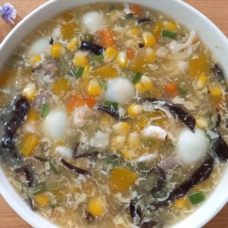 Bát súp trứng cút thơm ngon, nóng hổi đã hoàn thành, trang trí với hành lá và rau mùi.