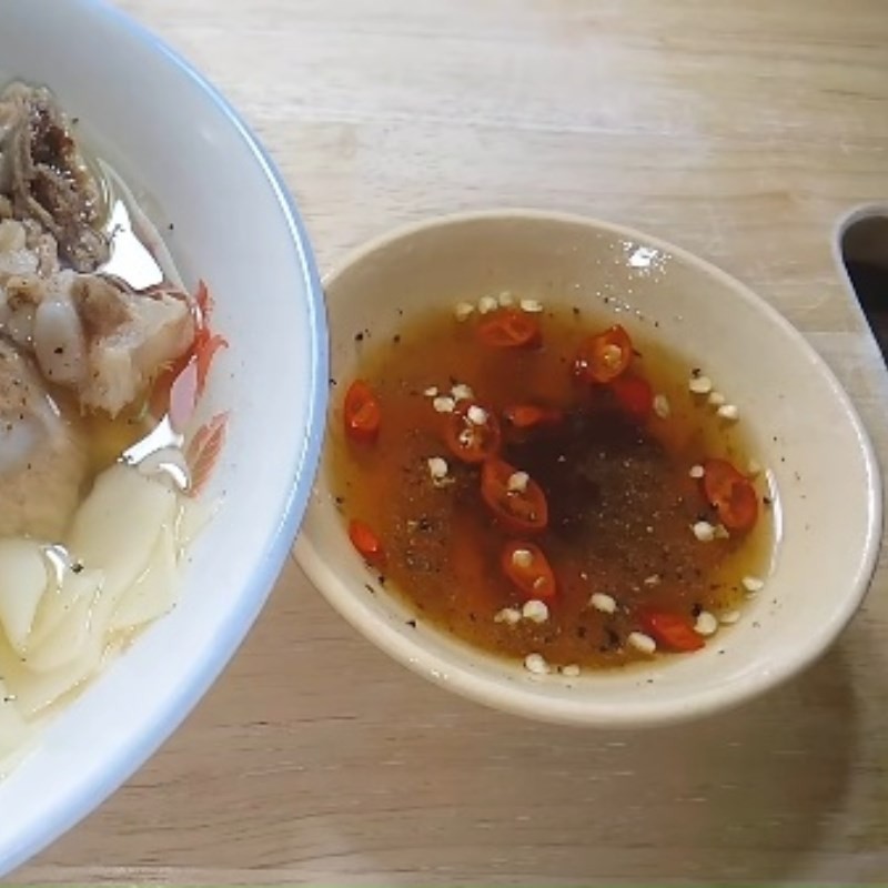 Một tô hoành thánh lá nóng hổi với nước dùng trong veo và các nguyên liệu tươi ngon