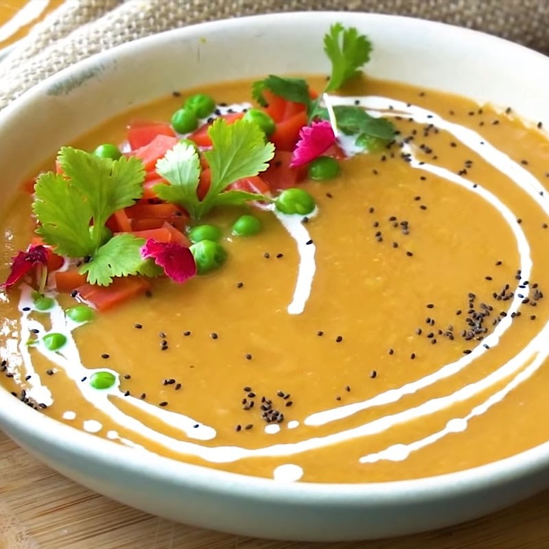 Trang trí súp cà rốt đậu Hà Lan với whipping cream và mè đen