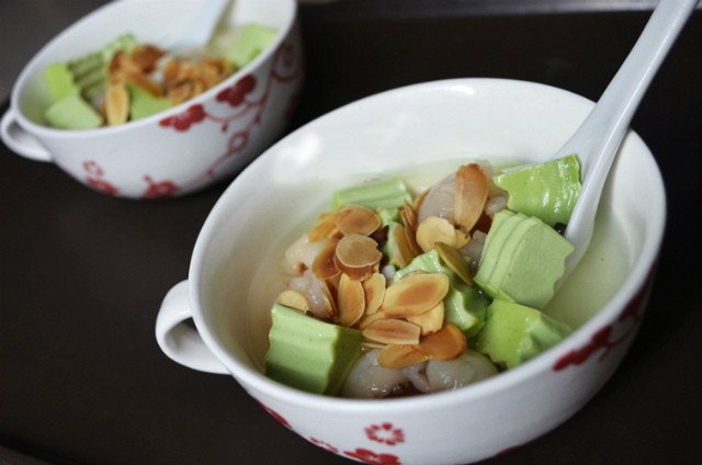 Rắc hạnh nhân rang thơm và chế nước đường vào chén chè khúc bạch trà xanh