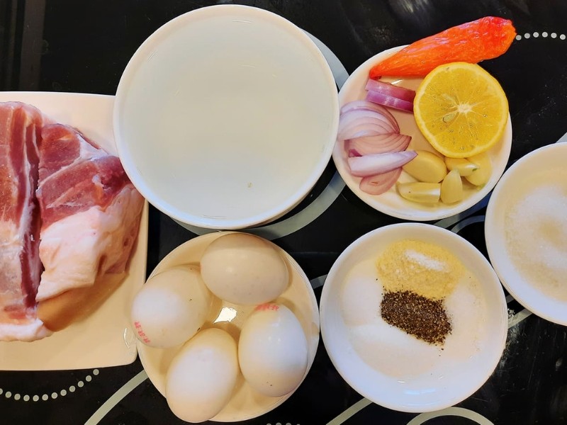 Nguyên liệu chuẩn bị cho món thịt kho tàu, bao gồm thịt ba chỉ, trứng, nước dừa, hành, tỏi, gia vị cần thiết để kho thịt bằng nồi nấu chậm