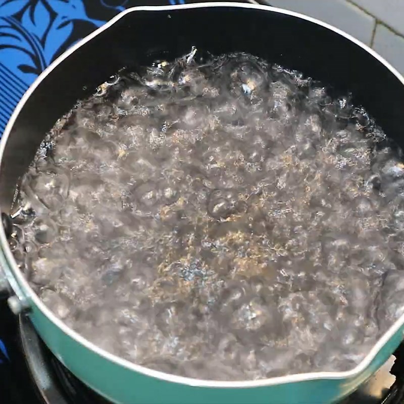 Chân gà được trụng trong nồi nước sôi có gừng, sả, hành