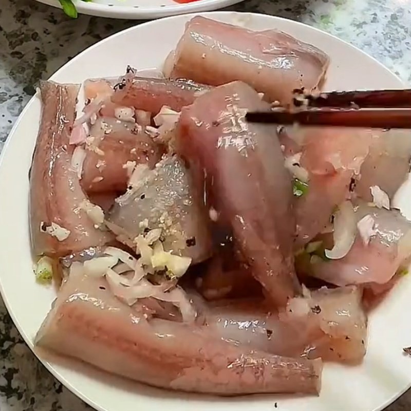 Cá khoai đang được ướp với hành tỏi băm, nước mắm, hạt nêm và tiêu để thấm vị