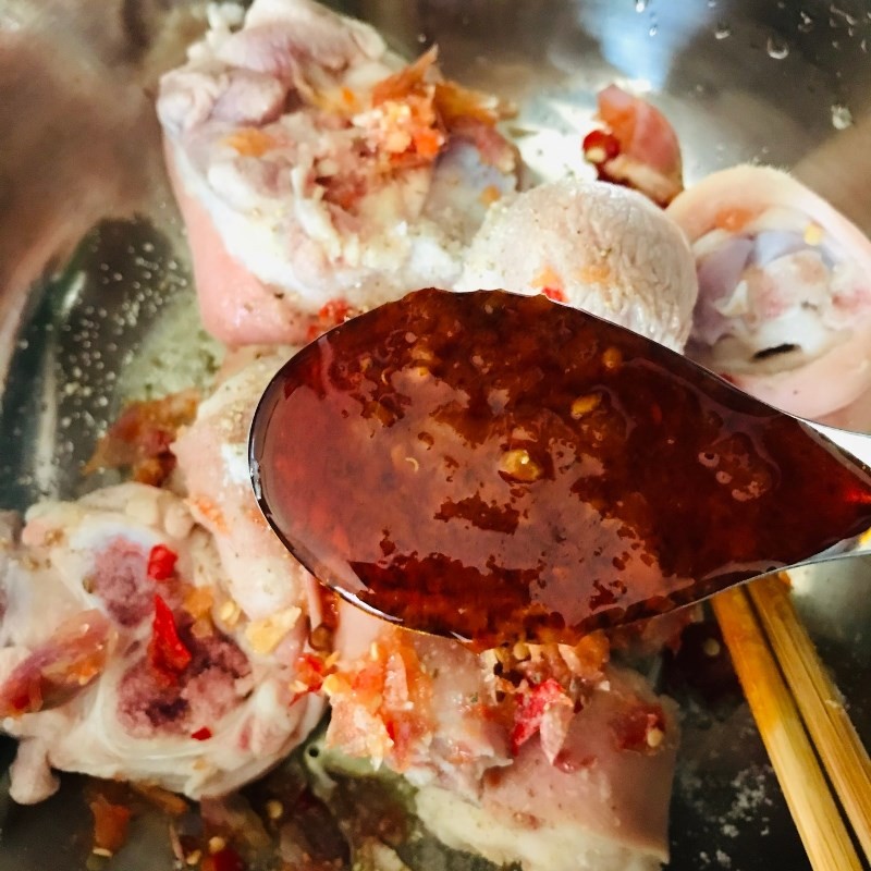 Thêm sa tế và hỗn hợp hành ớt giã nhuyễn vào giò heo để tăng thêm hương vị cay nồng, đậm đà cho món lagu