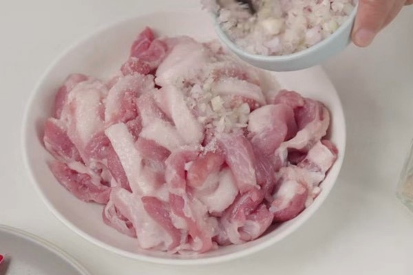 Thịt ba chỉ đang được ướp với đường và hành tím để nấu thịt rang cháy cạnh