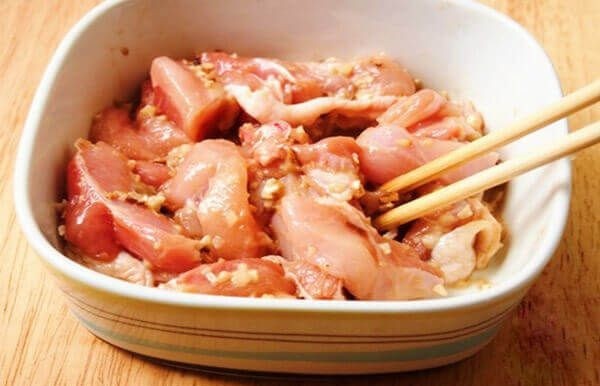 Thịt gà đang được ướp với gia vị để chuẩn bị làm món gà xào sả ớt