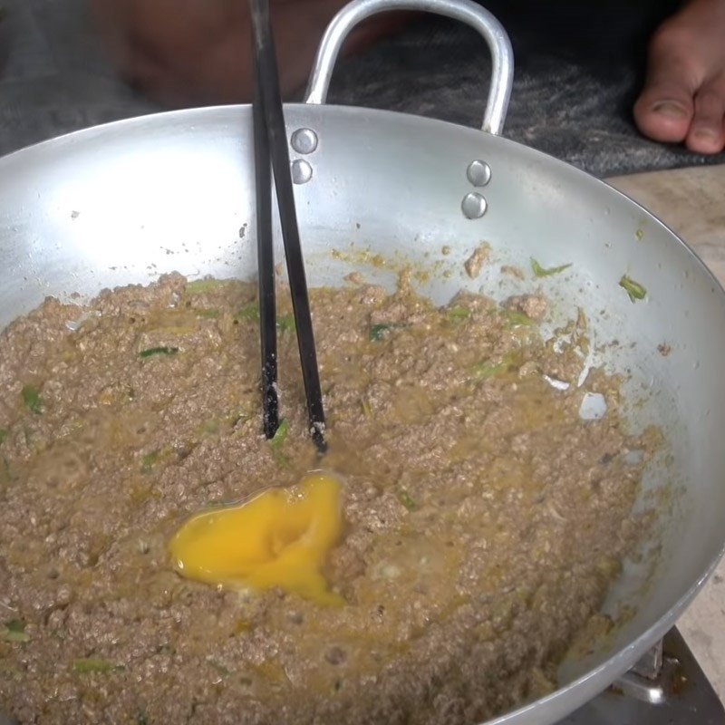 Hỗn hợp gạch và riêu cua đồng đang được xào trên chảo