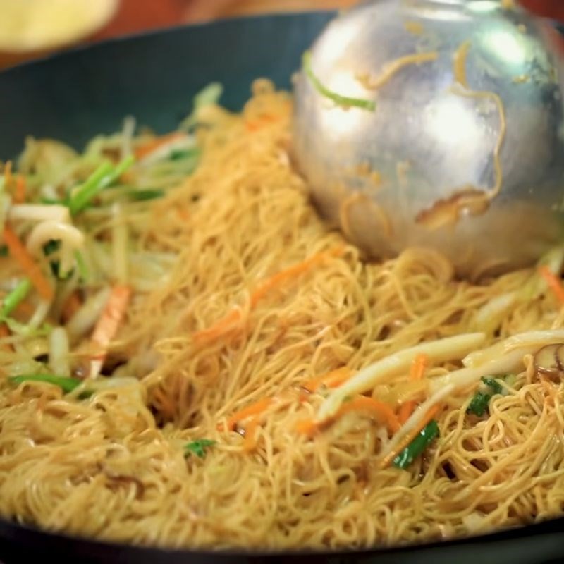 Cho mì đã áp chảo vào xào chung với rau củ và sốt