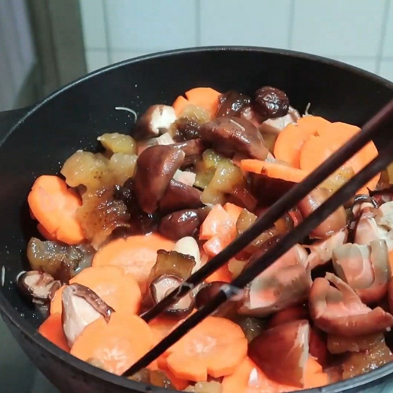 Thêm nước dùng gà vào chảo nguyên liệu đã xào, chuẩn bị cho bước hầm canh