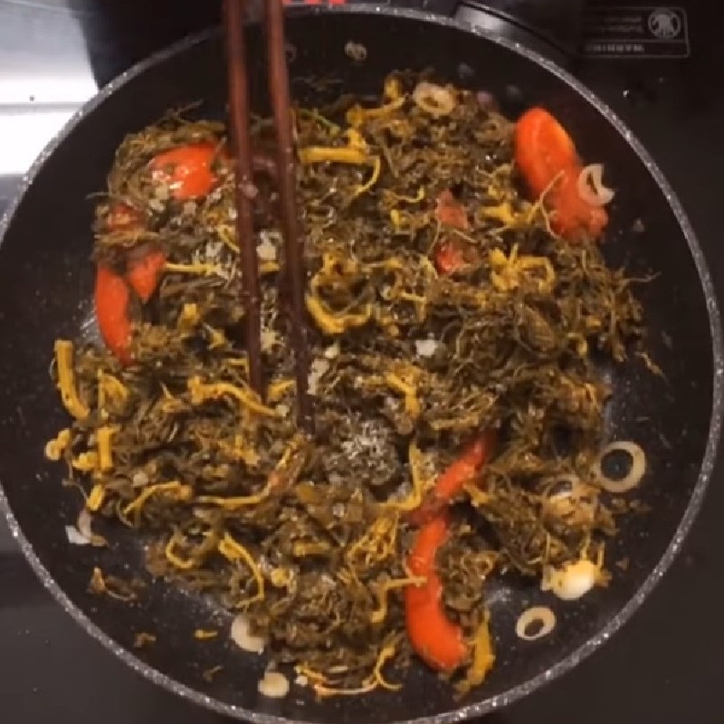 Rau sắn và cà chua được xào săn trước khi cho vào nồi canh