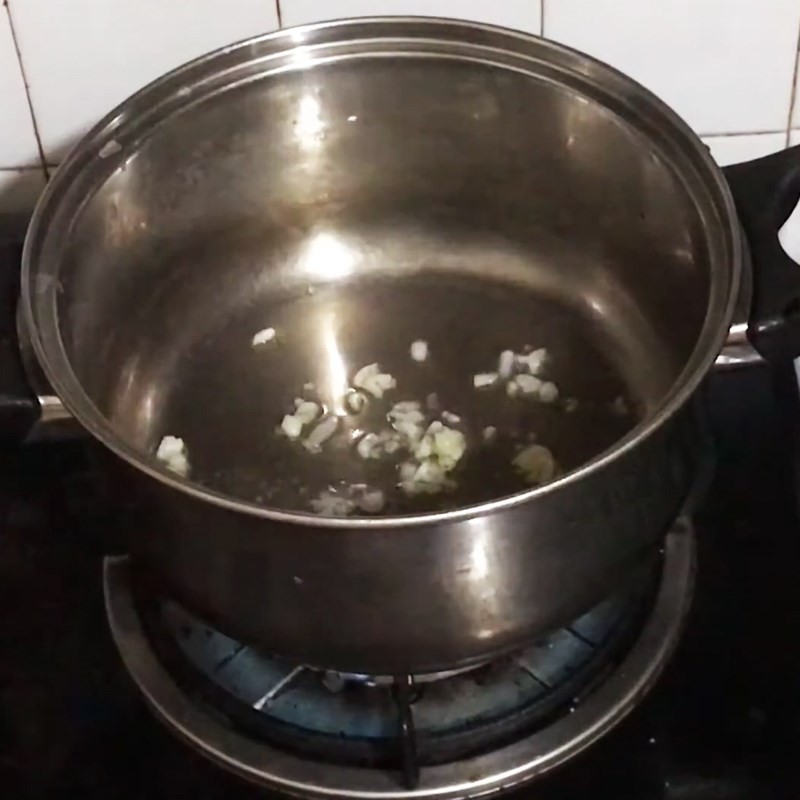 Rau bí được cho vào nồi và xào nhanh cùng tỏi