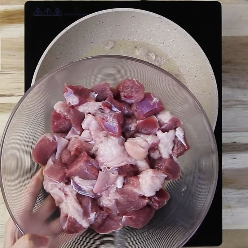 Thịt chân giò đang được xào săn trên chảo với hành phi