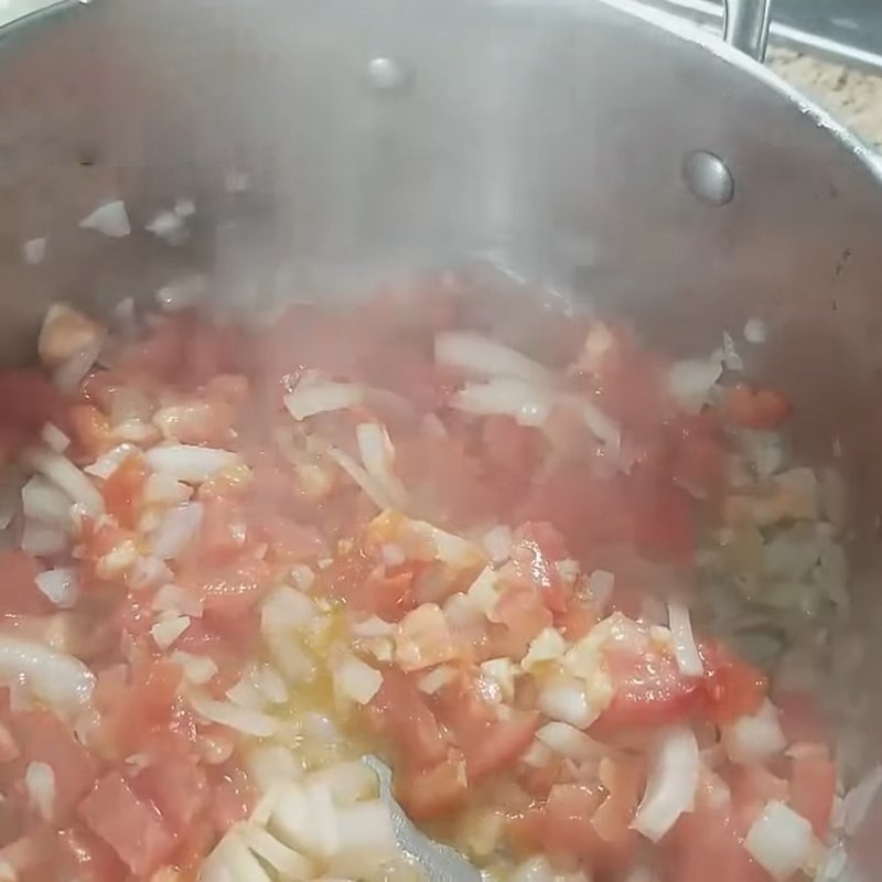 Thịt bò nạm đang được xào chung với hành, tỏi, hành tây và cà chua