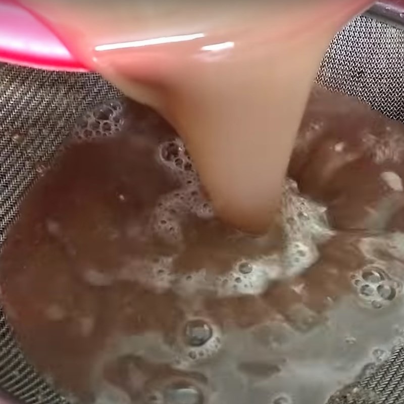 Lọc nước cốt cua đồng qua rây để loại bỏ bã