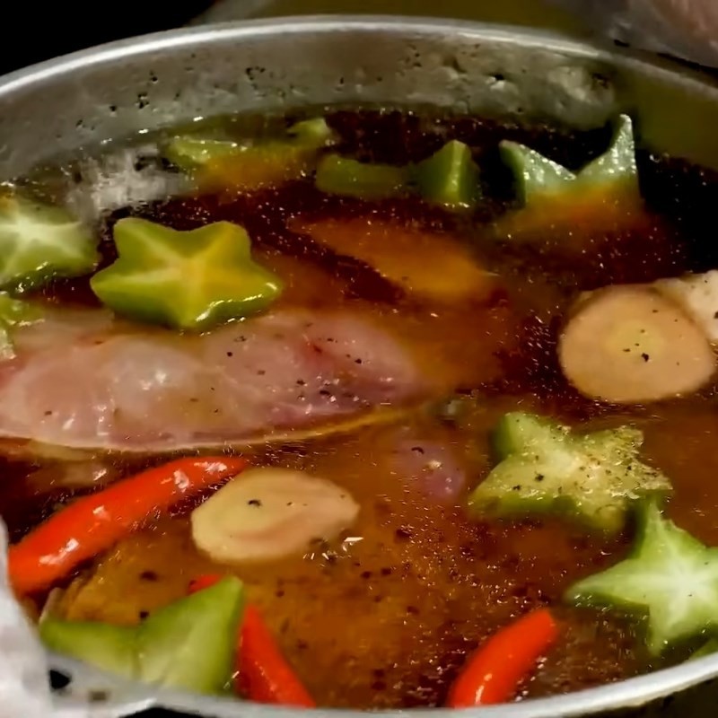 Nồi thịt kho riềng đang sôi liu riu trên bếp, tỏa hương thơm ngào ngạt