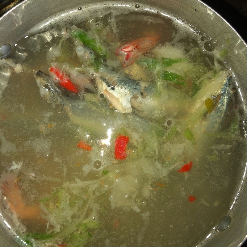 Thêm từng khúc cá vào nồi nước sôi để nấu canh cá me chua