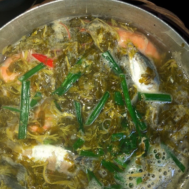 Hoàn thành món canh cá me chua bằng cách thêm hành lá thái nhỏ