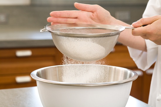 Rây bột vào hỗn hợp đường và nước cốt dừa - cách làm bánh bò nướng