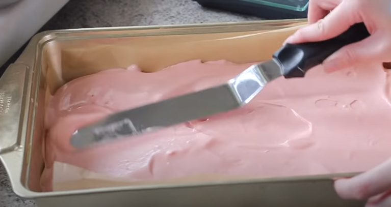 Từ từ đổ bột vào khuôn bánh rồi dùng dao dàn đều phần mặt bánh