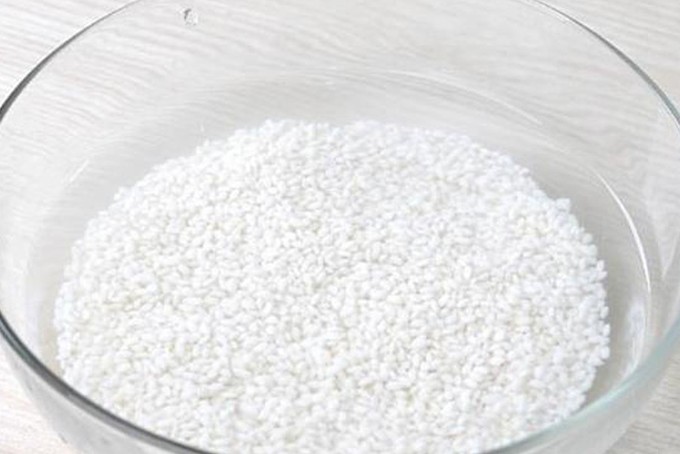 Ngâm gạo nếp đúng cách trước khi nấu xôi gấc để hạt xôi nở đều, không bị nhão