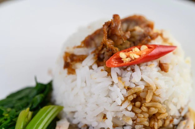 Người phụ nữ đang múc xôi nóng hổi từ tô ra đĩa, thể hiện sự tiện lợi của cách nấu xôi bằng lò vi sóng