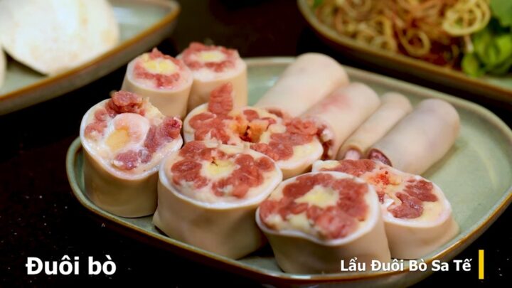 Đuôi bò đã được sơ chế sạch sẽ, chặt khúc vừa ăn, cùng các loại rau củ chuẩn bị cho món lẩu đuôi bò sa tế.