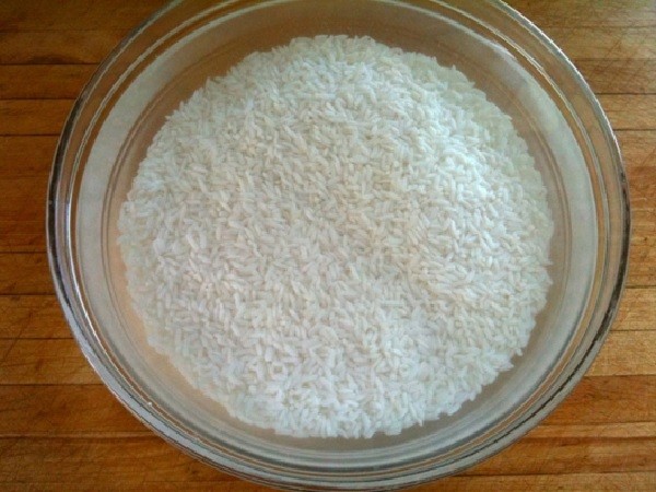 Gạo nếp và đậu xanh đang ngâm trong nước để chuẩn bị nấu xôi bằng chõ
