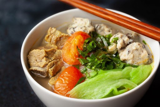 Cà chua thái miếng nhỏ chuẩn bị nấu canh sườn dọc mùng