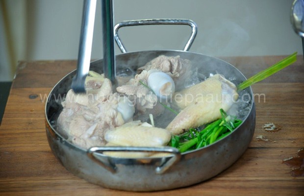 Chần xương ống heo và xương gà trong nước sôi để làm nước dùng lẩu cua đồng hải sản