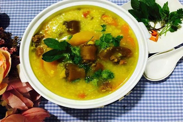 Tô cháo đuôi bò nóng hổi, thơm ngon với hành ngò và tiêu xay, minh họa cách nấu cháo đuôi bò thành công