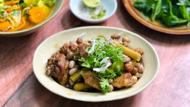 Gà hon đậu phộng được dọn ra đĩa, trang trí rau mùi và ớt sừng, sẵn sàng thưởng thức