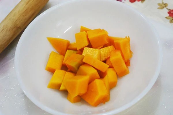 Bí đỏ tươi được gọt vỏ và thái thành từng miếng nhỏ chuẩn bị nấu cháo thịt gà