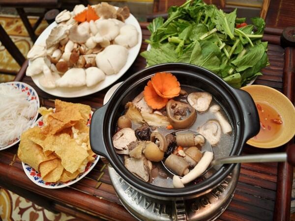 Nồi lẩu đuôi bò chua cay với màu sắc hấp dẫn, đầy đủ rau ăn kèm