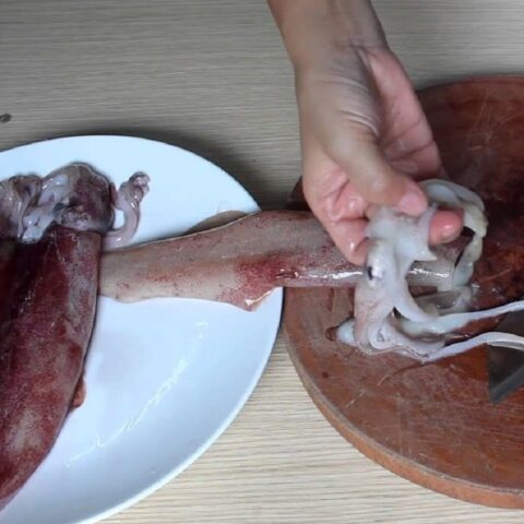 Bước sơ chế loại bỏ nội tạng mực để chuẩn bị nhồi thịt