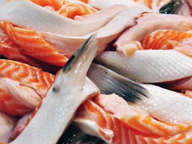 Sơ chế vây cá hồi sạch để loại bỏ mùi tanh, chuẩn bị cho cách nấu canh chua vây cá hồi