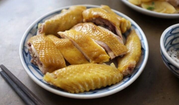 Gà luộc nguyên con vàng óng, mềm mại trên đĩa, minh họa cho cách nấu gà nhanh mềm chuẩn vị